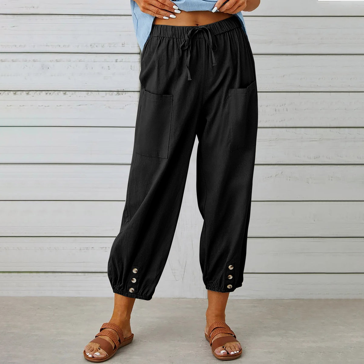 Drawstring tapered trousers in black showing the ankle buttons
