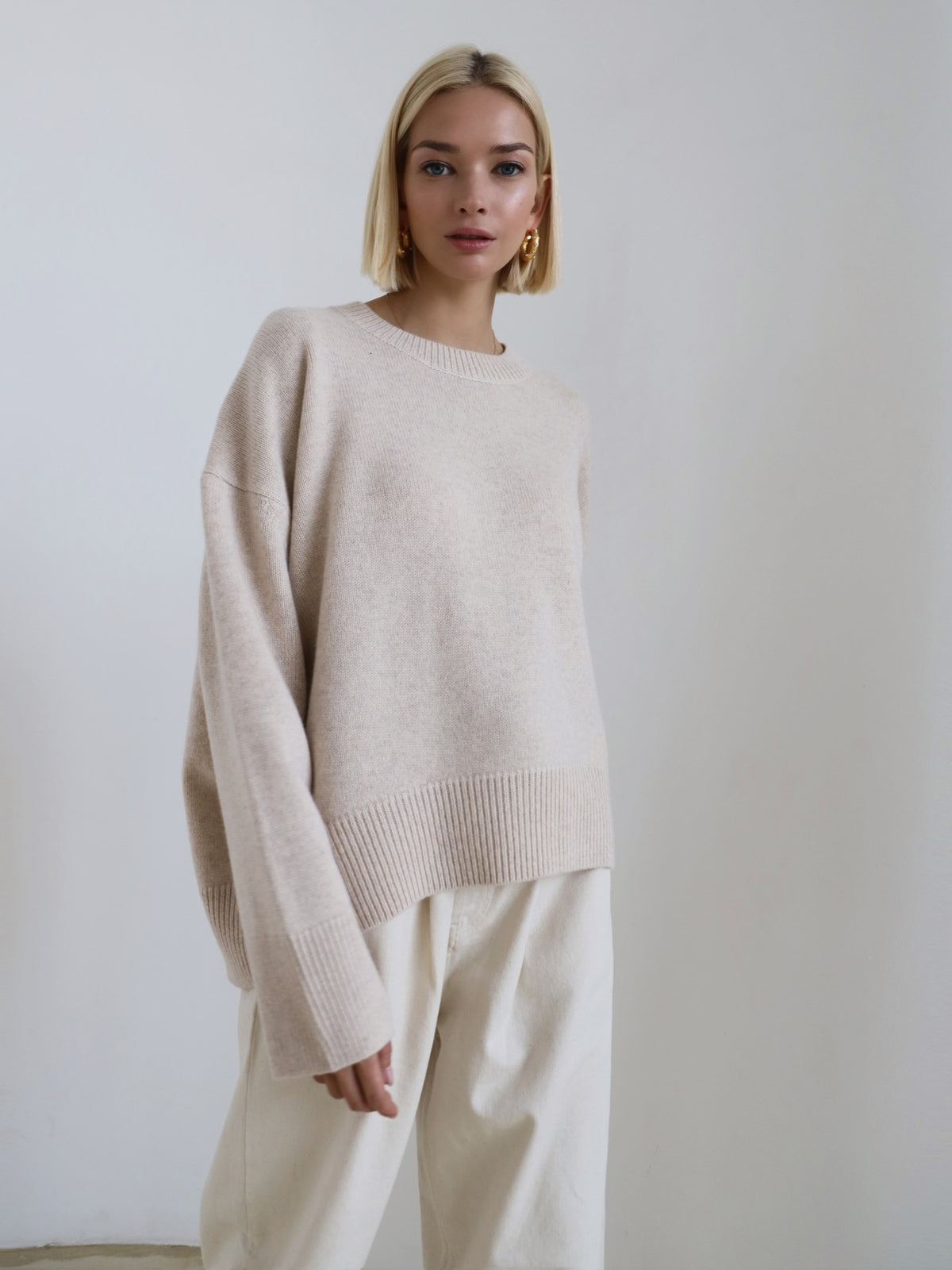Relaxed knit sweater in apricot on a studio background