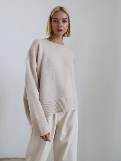 Relaxed knit sweater in apricot on a studio background